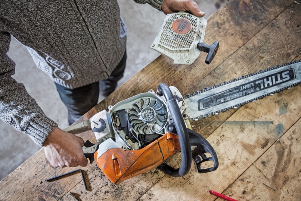 Técnico a reparar uma motosserra STIHL na bancada